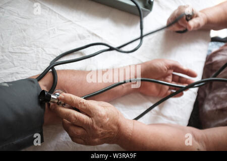 Arzt prüft Patienten Blutdruck, POV Stockfoto