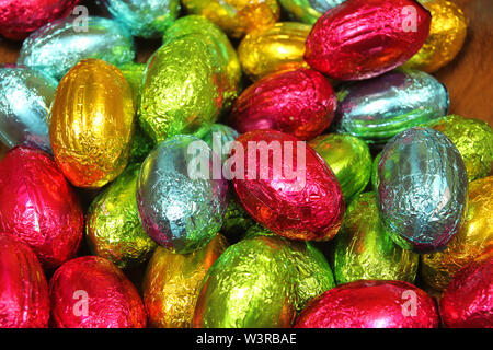 Stapel von Schokolade Eier in mehreren farbigen Folien. Ostern Süßigkeiten Stockfoto