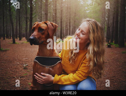 Eine attraktive junge Frau liebt gehorsamen Hund Stockfoto