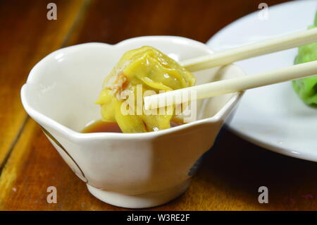 Gedünsteter chinesische Knödel Kommissionierung in chopstick Soße Stockfoto
