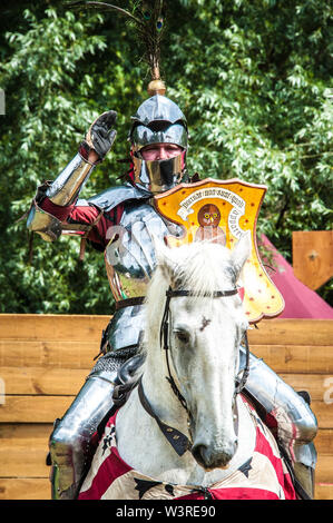 Eine gepanzerte Ritter auf seinem Ladegerät begrüßt während Turnier Woche in Arundel Castle, Foto © Julia Claxton Stockfoto