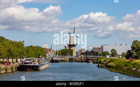 Rotterdam, Niederlande. Traditionelle Windmühle und Boote in Maas am Hafen. Stockfoto