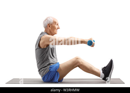 Volle Länge Profil geschossen von einem älteren Mann Training mit Kurzhanteln und sitzen auf einer Gymnastikmatte auf weißem Hintergrund Stockfoto