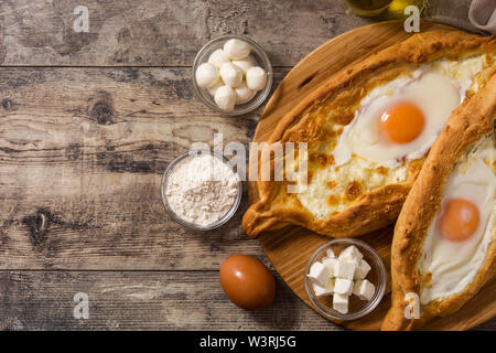 Traditionelle Adjarian georgische Khachapuri mit Käse und Ei auf Holztisch. Ansicht von oben. Copyspace Stockfoto