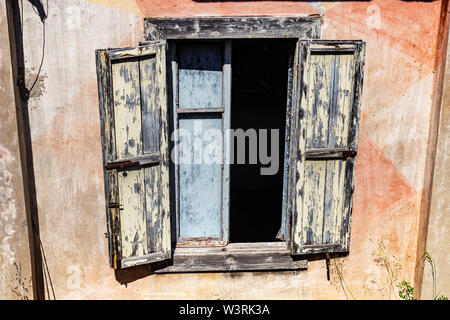 Außenfenster und gebleichtem Holz- Shutter Detail einer Verfallenen WW2 Gebäude, an der Klippe Rand #2; Baia Sardinia, Sardinien, Italien. Stockfoto