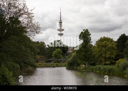 Der Heinrich-Hertz-Turm hinter Planten un Blomen, einem botanischen Garten und Park mit einem See (Parksee) in Hamburg. Stockfoto