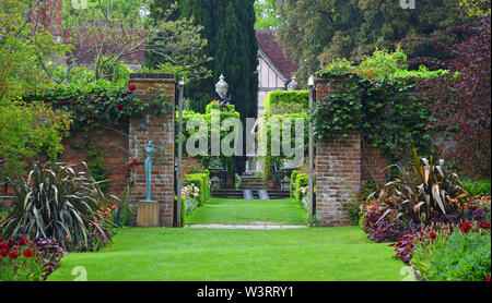 Gartentor mit Pflanzen und Statue. Stockfoto