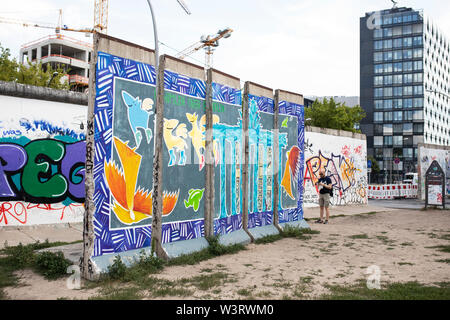 Street Art an der ehemaligen Berliner Mauer bildet die East Side Gallery in der Muhlenstraße in Berlin. Stockfoto