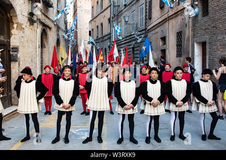 Eine Reihe von Jungen in mittelalterlichen Kostümen und gewandungen sind Sie bereit bei der jährlichen Palio in Siena, Italien bis März. Stockfoto