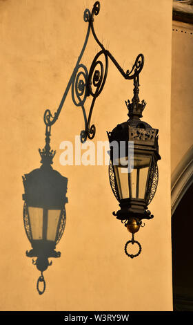 Reich verzierten schmiedeeisernen Lampe wirft einen Schatten auf den wunderschönen Tuchhallen, Krakau, Polen, Europa. Stockfoto