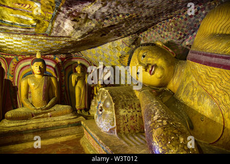 Buddha Statuen in den lackierten Dambulla Höhlentempeln mit religiösen Themen, die aus dem 1. Jahrhundert v. Chr., Matale Distrikt, Sri Lanka, Asien. Stockfoto