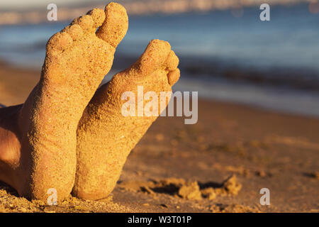 Füße an einem Sandstrand in der Sonne mit der Kopie Raum Stockfoto