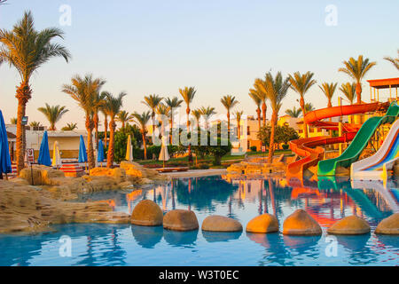 Wasser bunte Regenbogen Folien mit Swimmingpool im Hotel in der Morgendämmerung in Ägypten. Wasser sport Intertainment Stockfoto