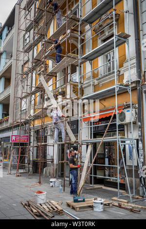 Belgrad, Serbien, 13. Juli 2019: Arbeiter auf einem Gerüst arbeiten an der vorderen Wand eines alten Gebäudes in Zemun Stockfoto