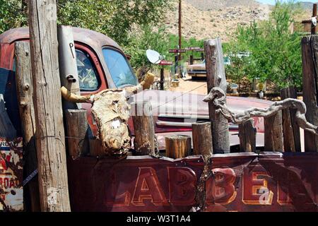 OATMAN (Arizona), USA - AUGUST 7. 2009: Blick auf Red rusty moonshine Oldtimer mit dem Schädel von Buffalo hängend an einem Zaun in der Wüste Stockfoto