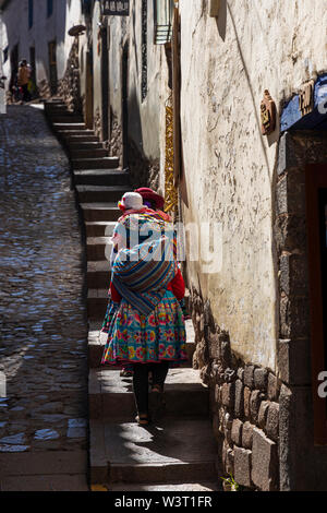 Frauen in traditionellen Peruanischen Kleid klettern Schritte in der Calle Hatunrumiyoc, Cusco, Peru, Südamerika Stockfoto