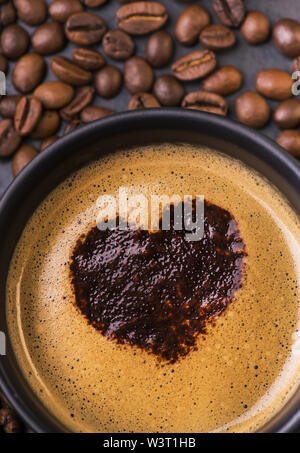 Silhouette eines Herzen gezeichnet mit Kakao in eine Tasse schwarzen Kaffee Stockfoto