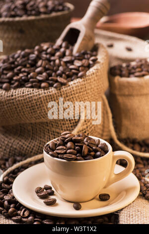 Einem alten rustikalen Holztisch top mit Kaffeebohnen in Jute Sack Stockfoto