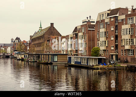 Leiden, Holland, Niederlande, April 18, 2019, die Altstadt von Leiden mit historischen Kähne und Wohnhäuser, Yachten und Hausboote Stockfoto