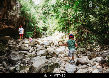 Jungen und Mädchen Kletterfelsen beim Wandern mit Papa. Stockfoto