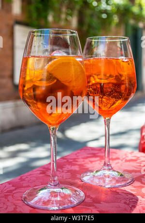 Ein Glas mit hellen orange Flüssigkeit, Eis und eine Scheibe Orange, Spritz Aperol cocktail Stockfoto