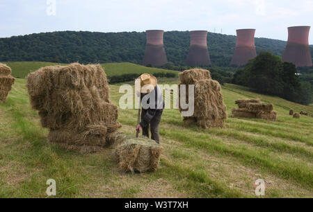 Bauer Stapeln Heuballen von Hand Großbritannien Stockfoto