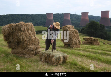 Bauer Stapeln Heuballen von Hand Großbritannien Stockfoto