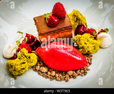 Gericht des mit Michelin-Sternen ausgezeichneten Küchenchefs Frederik Desch vom Laudensacks Restaurant, Bad Kissingen, Deutschland. Himbeere trifft Schokolade: Als Tartlet, mit Schokoladenbrösel und Pistazie mariniert Sorbet Stockfoto