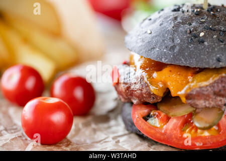 Close-up Cheeseburger mit Salat, Tomaten, Zwiebel, und geschmolzenem American Käse Stockfoto