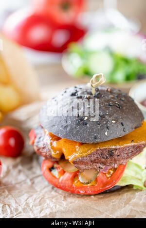 Close-up Cheeseburger mit Salat, Tomaten, Zwiebel, und geschmolzenem American Käse Stockfoto