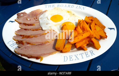 Der Schinken Mittagessen, Spiegelei und Kartoffelchips auf Einer ovalen Platte am Bord Inn Lealholm, North Yorkshire, England serviert. Stockfoto