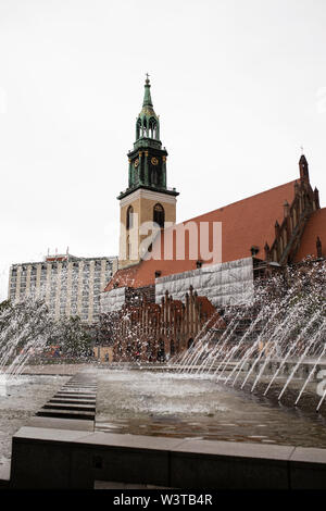 Das Äußere der Marienkirche, der evangelisch-gotischen Kirche in der Nähe des Alexanderplatzes in Berlin, Deutschland, mit dem Wasserkaskaden-Brunnen. Stockfoto