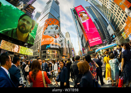 Mitarbeiter mit ihren Familien und Freunden sammeln an der riesigen Bildschirm an der Nasdaq Börse in Times Square in New York für das Debüt des DouYu International Holdings Ltd. Börsengang am Mittwoch, 17. Juli 2019. DouYu ist die größte live-Streaming Plattform in China und wird von Tencent Holdings Ltd. unterstützt die Bewertung der Unternehmen bei $ 3,73 Mrd. ist es die größte chinesische IPO im Jahr 2019. (© Richard B. Levine) Stockfoto