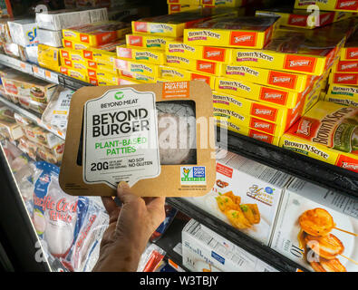 Eine anspruchsvolle Käufer entscheidet sich für ein Paket von über Fleisch aus der Tiefkühltruhe im Supermarkt in New York am Dienstag, 16. Juli 2019. Blaue Schürze angekündigt, dass es darüber hinaus Fleisch Menüs wird zu seinem Repertoire hinzuzufügen. (© Richard B. Levine) Stockfoto