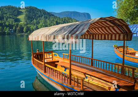 Schönen hölzernen Boot auf dem berühmten See von Bled in Slowenien. Bleder See, das Schloss und die Insel bekannt, ist beliebtes Reiseziel. Touristische boote sind für den Sommer sightseeing Touren auf der Blue Lake verwendet. Stockfoto