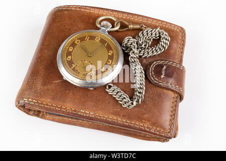 Lederetui und eine alte Uhr auf einem weißen Tisch. Persönliche Dokumente in Leder. Hellen Hintergrund. Stockfoto