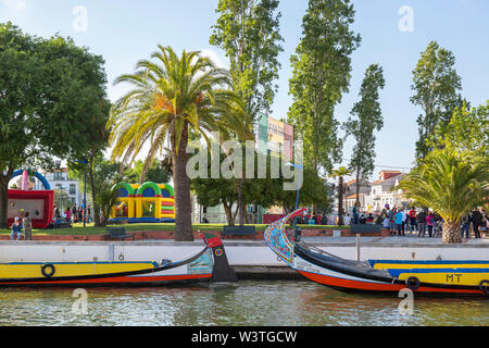 Bunte Szene der moliceiro Boote auf der Cojo Kanal mit Park Andy farbenfrohe Gebäude darüber hinaus. Touristen genießen den Abend. Stockfoto