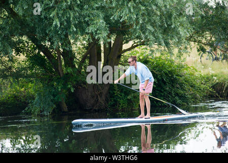 Cambridge UK, 2019-07-17. 8 Mann auf paddleboard auf dem Fluss Cam während der jährlichen Stadt Stößen Stockfoto