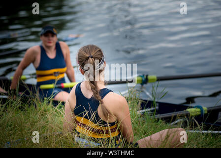 Cambridge UK, 2019-07-17. Zwei weibliche Ruderer Ruhe vor der Teilnahme an der jährlichen rcity Fluss Unebenheiten auf dem Fluss Cam statt Stockfoto