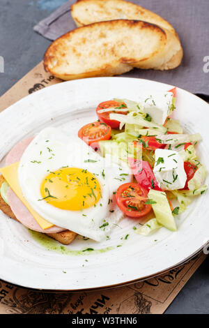 Spiegelei auf Toast Sandwich Brot von Oben nach Unten anzeigen. Gesundes Englisches Frühstück mit Tomaten Salat und Schinken. Pflanzliche Morgen Snack für zwischendurch. Traditionelle Roaste Stockfoto