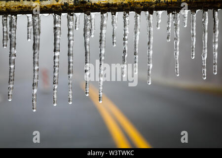 Eiszapfen bildeten sich nach einem Eissturm auf einer Barriere über dem Blue Ridge Parkway in North Carolina. Stockfoto