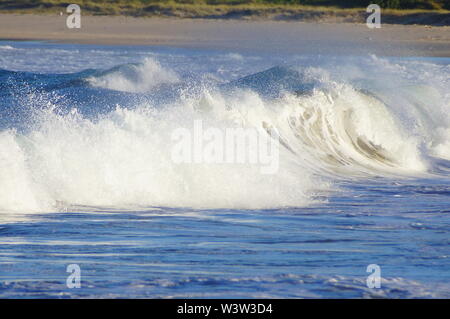 Wellen, die auf einen Strand Stockfoto