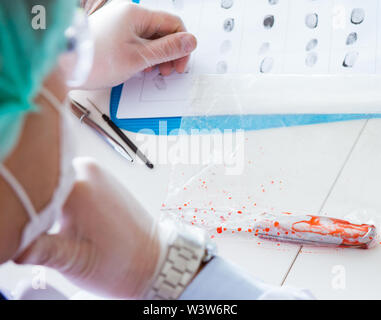 Die kriminologen Polizei Chemiker bei der Kriminalität Beweise suchen Stockfoto