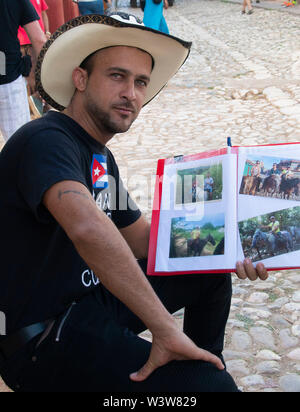 Eine junge gut aussehende Kubanischen cowboy sitzt mit dem Buchen von Touren und Pferde in Trinidad, Kuba Stockfoto