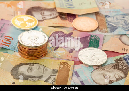 Mehrere cryptocurrencies, bitcoin, des Astraleums, litecoin, Welligkeit, durch Geld aus Venezuela begleitet. Stockfoto