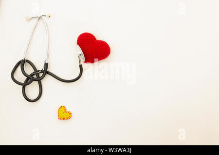 Herzen Gesundheit und Prävention. Stethoskop und roten Herzen häkeln auf weißem Hintergrund isoliert mit Platz für Text. Stockfoto