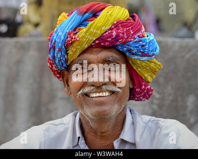 Ältere indische Rajasthani Mann mit einem farbenfrohen traditionellen Rajasthani Turban (pagari) Lächeln für die Kamera. Stockfoto
