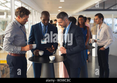 Geschäft Leute diskutieren über digitale Tablet während Kaffee im Amt Stockfoto