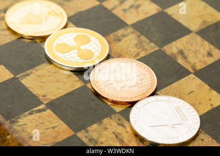 Mehrere cryptocurrencies, bitcoin, des Astraleums, litecoin, Welligkeit am Schachbrett. Stockfoto