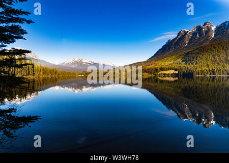 Berge im Morgenlicht in ruhigen See spiegeln Stockfoto